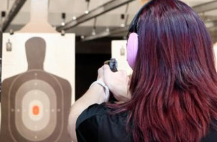 Woman Shooting Target at Indoor Range
